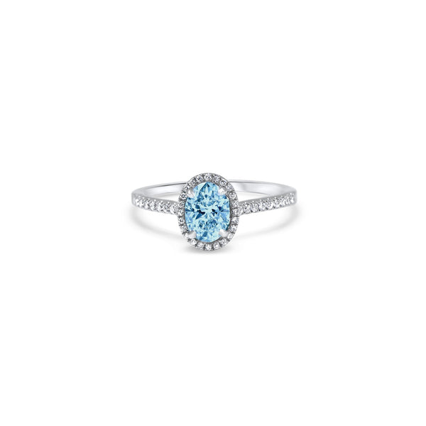 Bague de fiançailles avec d'un diamant culture light blue taille ovale de 0.52ct. entouré d'un halo en micropavage, monté sur un anneaux embelli d'un fin micropavé. 