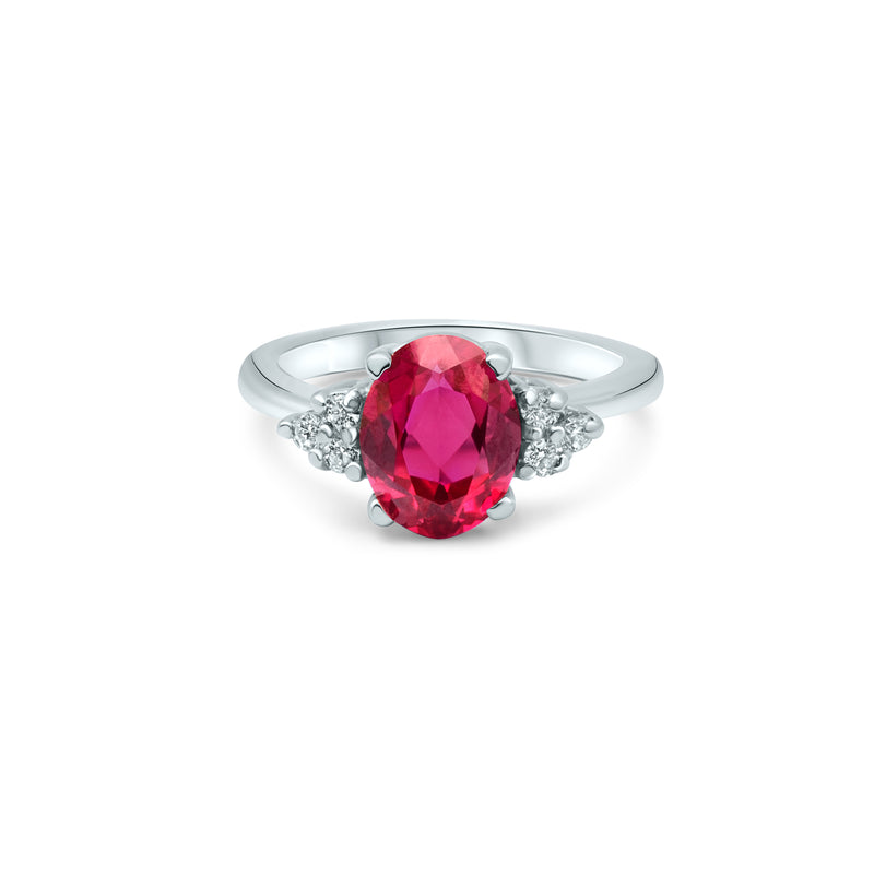 Solitaire avec un rubis cultivé taille ovale de 1.5ct. monté sur un anneau aux lignes épurées. Trois diamants encadrent la pierre de chaque côté et mettent en lumière sa couleur.